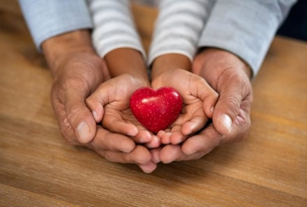 Father and son hands holding heart craft